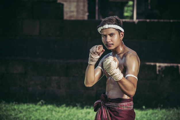 Foto gratuita un pugile gli legò una corda in mano ed eseguì un combattimento, le arti marziali della muay thai.