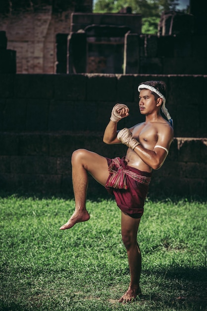 Foto gratuita un pugile gli legò una corda in mano ed eseguì un combattimento, le arti marziali della muay thai.