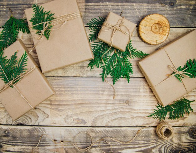 Коробки набиты крафт-бумагой и натуральным шпагатом на деревянном фоне. служба доставки.экологичный материал. ремесло ручной работы. концепция рождества и нового года.