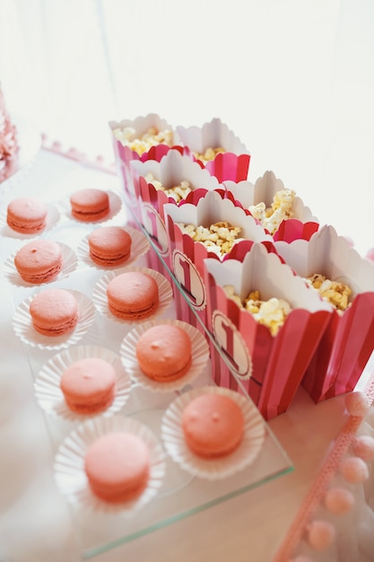 Boxes with pop-corn stand before dish with macaroons