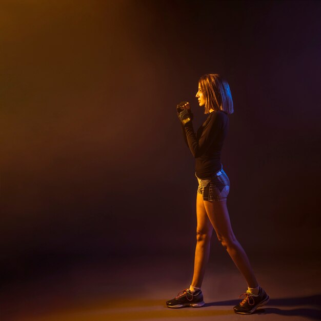 Boxing woman in dark studio