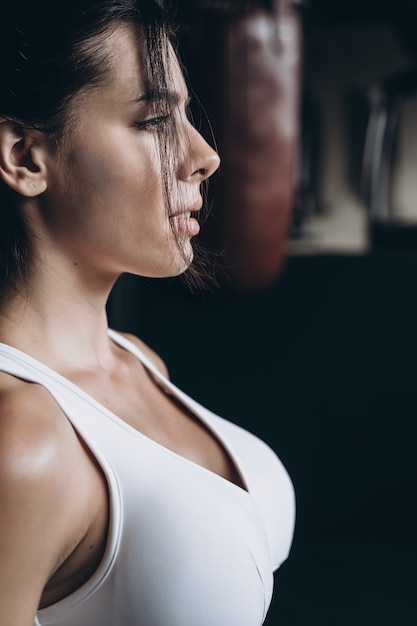 Boxing woman posing with punching bag. Strong and independent woman concept