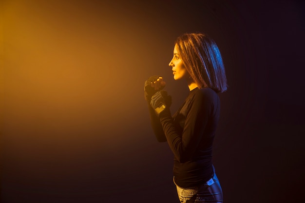 Foto gratuita donna boxe in luce gialla