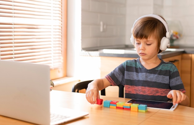 Boy arranging toys online school interactions