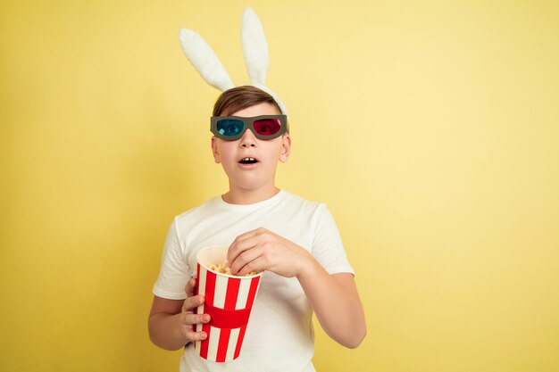 Boy as an Easter bunny on yellow wall