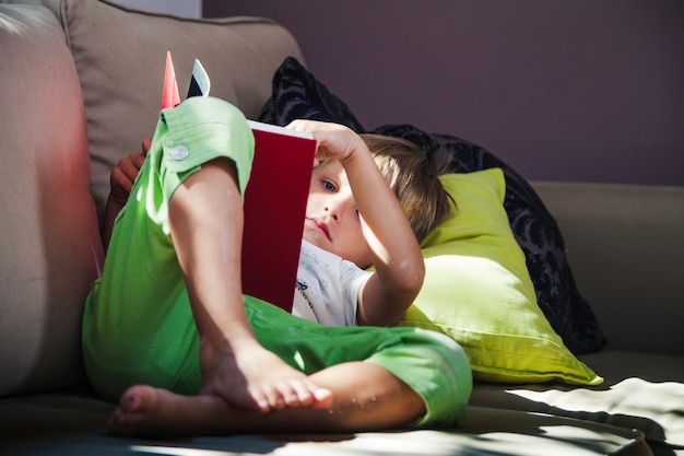 Бесплатное фото Мальчик дома с книгой