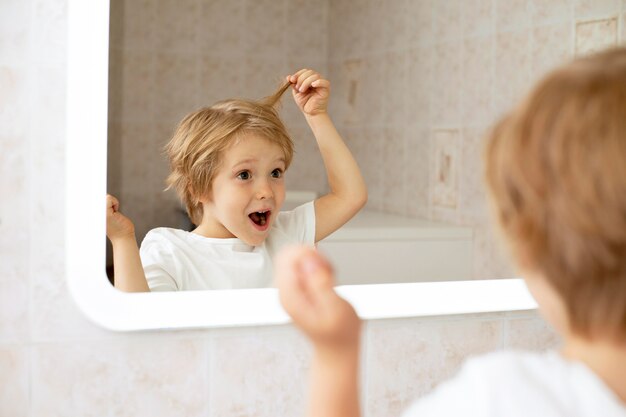 Boy in bathroom looking in mirror