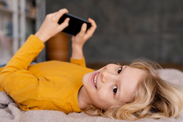 モバイルで遊ぶベッドの少年