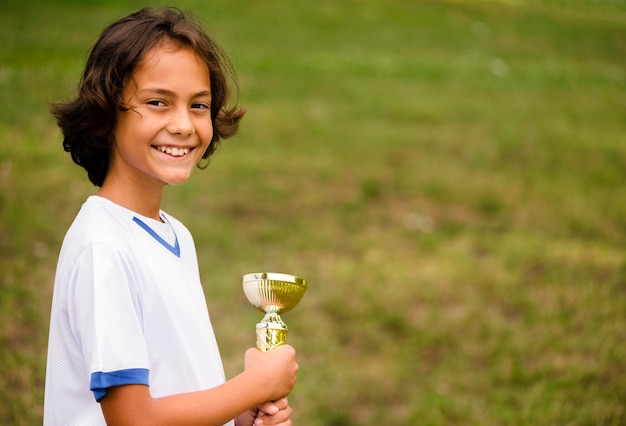 Boy being victorious after a match of football with copy space