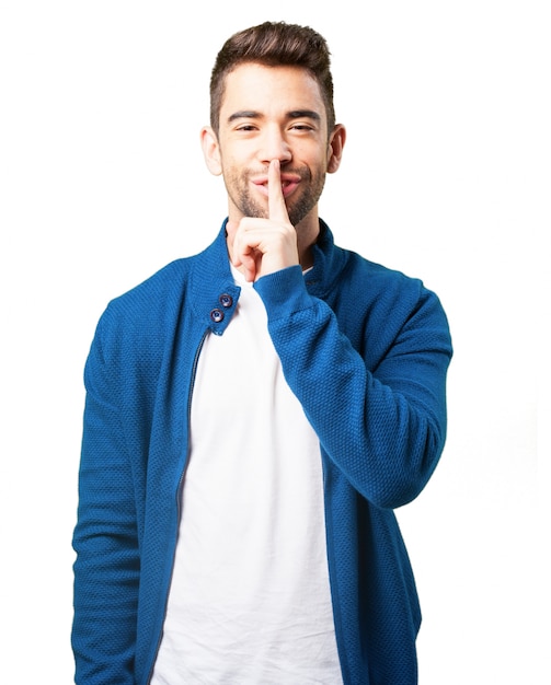 Boy in a blue jacket smiling and asking for silence