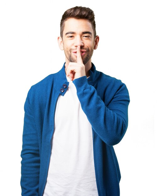 Boy in a blue jacket smiling and asking for silence