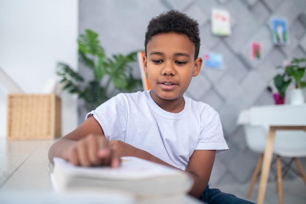 Boy carefully looking at book reading title