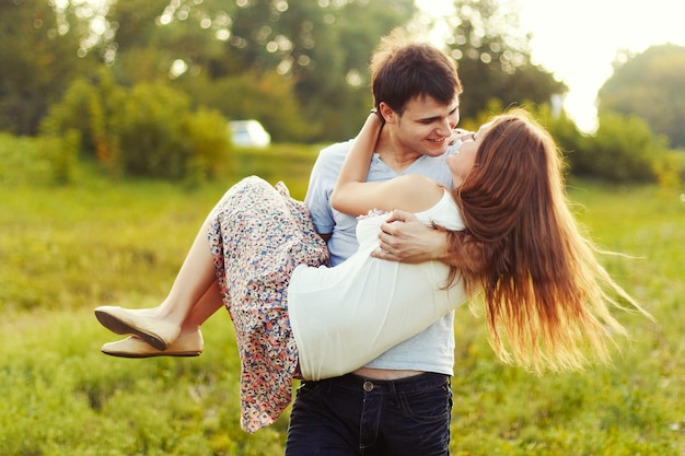 Boy carrying his girlfriend in the meadow