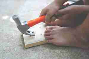 Free photo boy child holding a hammer tool.