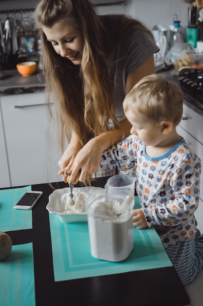 boy child with mom cooking in the kitchen pie