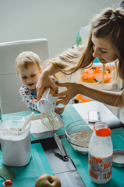 boy child with mom cooking in the kitchen pie