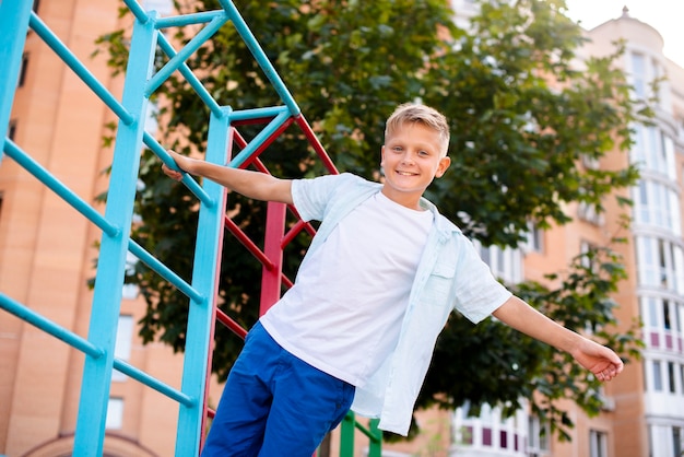 Foto gratuita ragazzo aggrappato al tubo con una mano