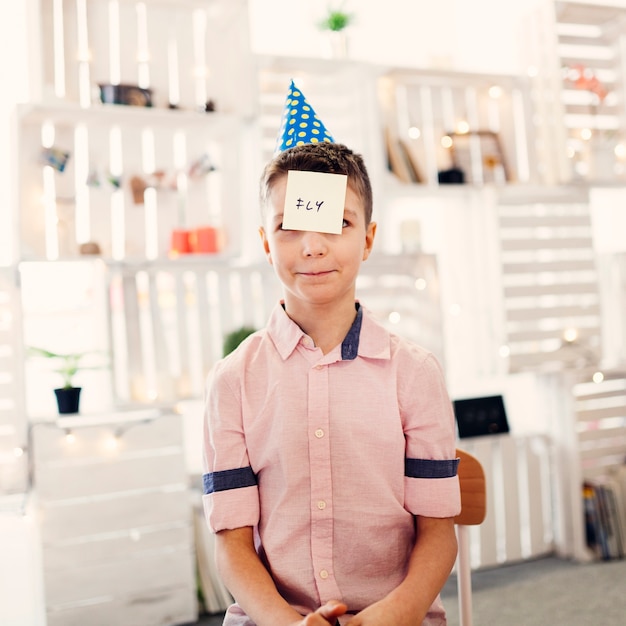 Free photo boy in colored cap sitting