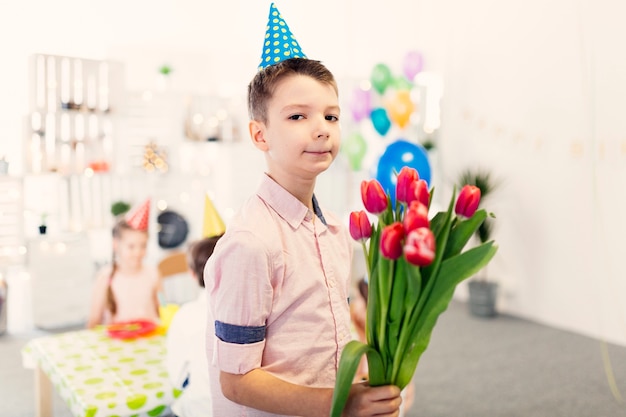 Free photo boy in colored cap with flowers