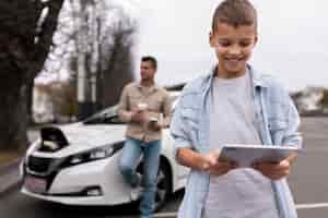 Free photo boy and dad near an electric car