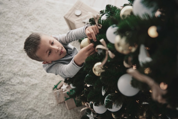 クリスマスツリーを飾る少年