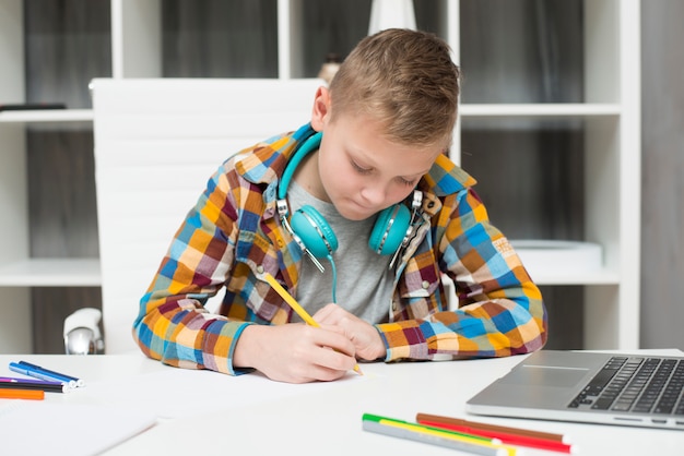 Free photo boy doing homework with laptop