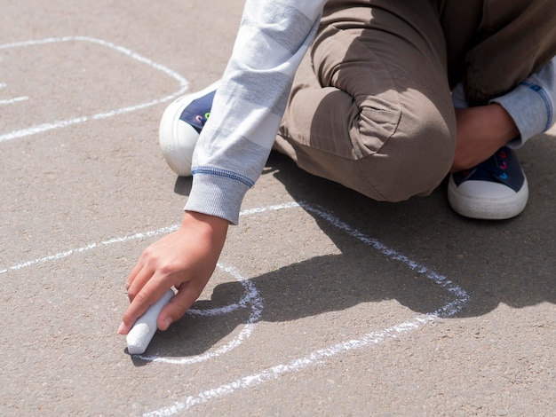 Boy drawing on the street with chalk