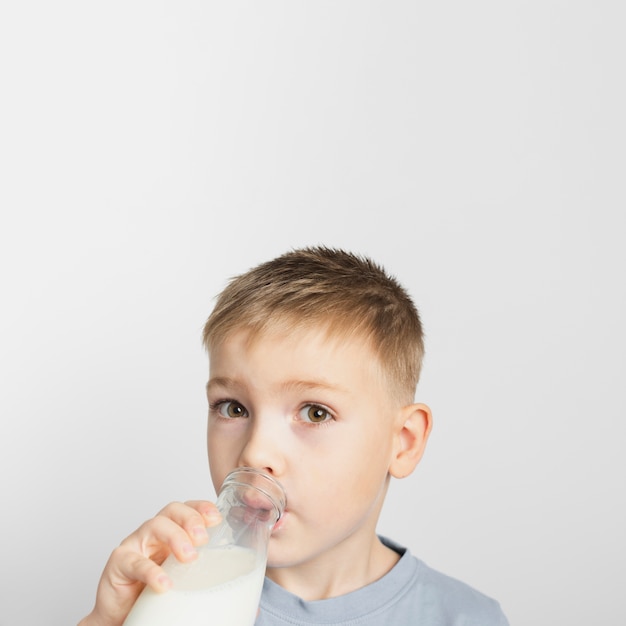 Мальчик пьет молоко из бутылки