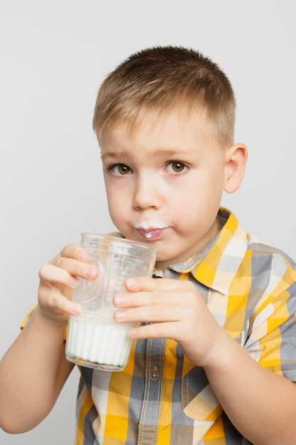 Foto gratuita ragazzo che beve latte dal vetro