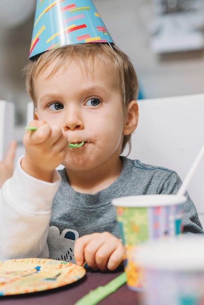 Free photo boy eating birthday cake