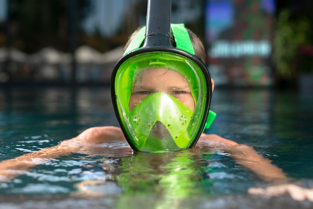 Boy enjoying his day at the swimming pool with scuba mask