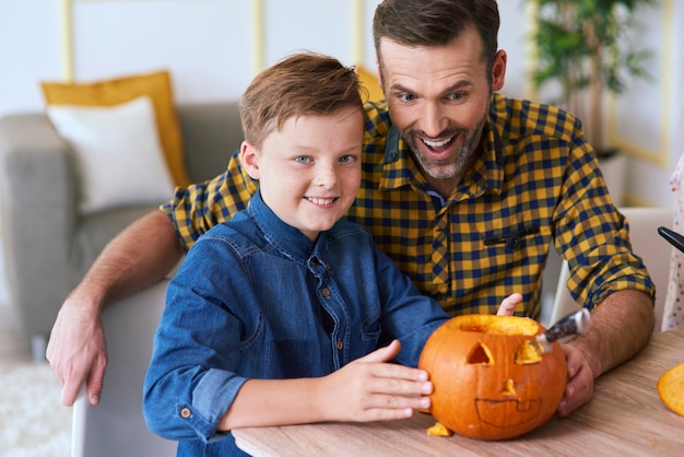 Free photo boy and father carving pumpkin