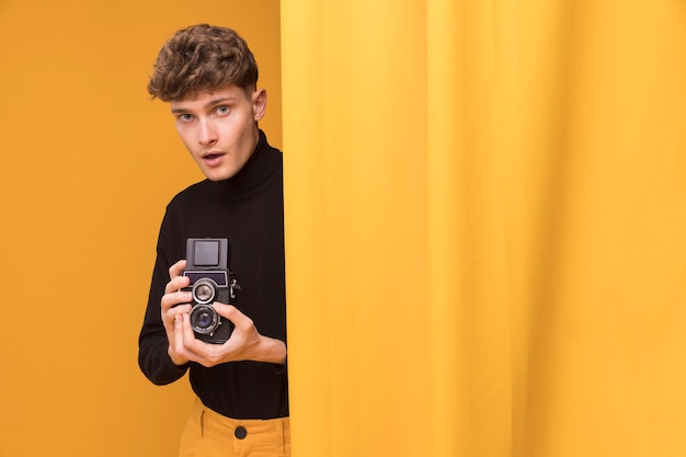 Boy filming with a camcorder in a yellow scene