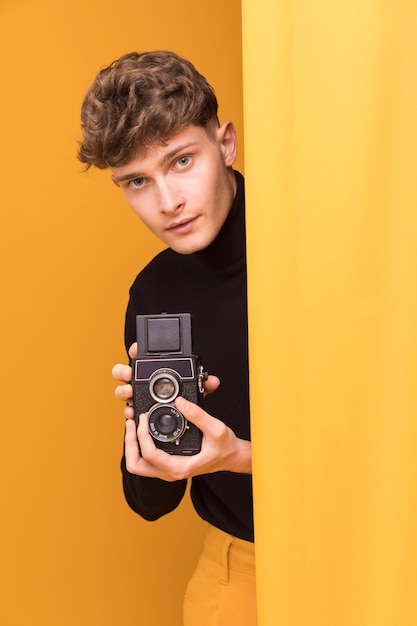 Free photo boy filming with a camcorder in a yellow scene