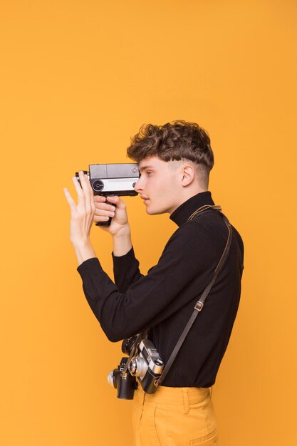 Boy filming with a camcorder in a yellow scene