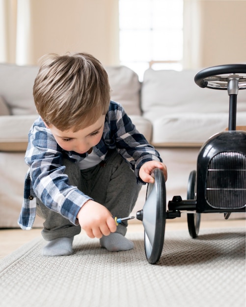 レースカーから車輪を固定している少年