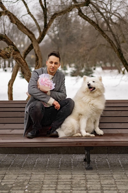 Free photo boy friend with a bouquet of pink flowers hydrangea waiting for his girl friend and walking and playing with a dog. outdoors while snow is falling. valetnine`s day concept, wedding proposal.
man goes