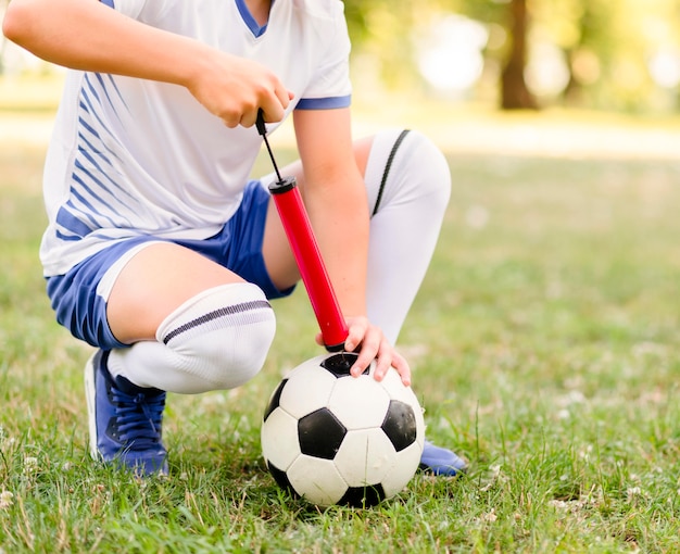 Boy getting ready his football for a new match close-up