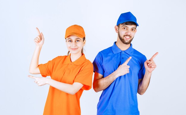 Boy and girl in blue and yellow uniforms showing something above. 