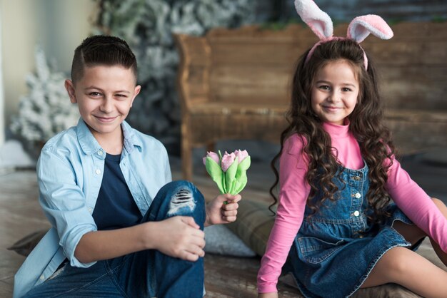 Boy and girl in bunny ears with tulips