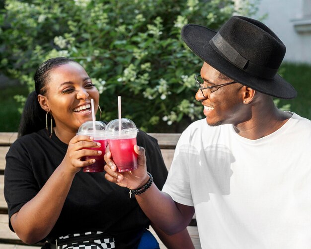 Boy and girl cheering with smoothies