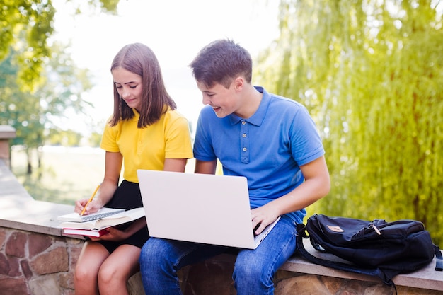 Boy and girl doing homework in park