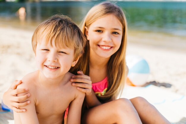 Мальчик и девочка счастливо улыбаясь на берегу моря