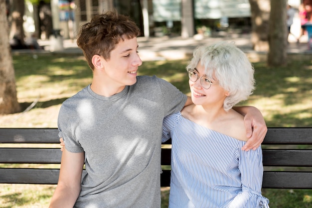 Boy and girl holding each other on a bench