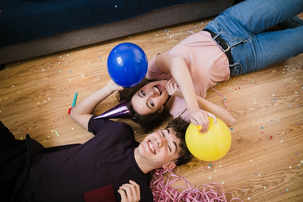 Boy and girl laying on the floor with balloons