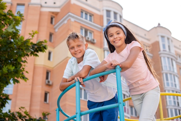 Boy and girl leaning on a metal bar