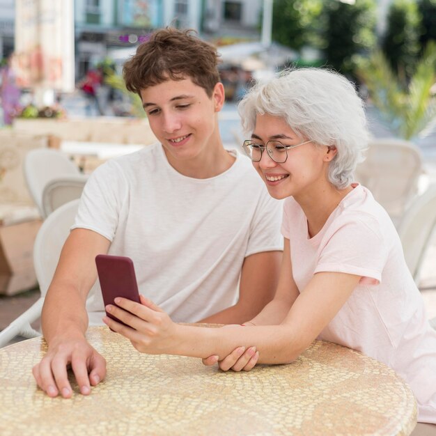 男の子と女の子の外の電話で探しています