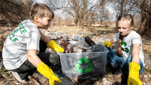 Мальчик и девочка на сборе пластикового мусора