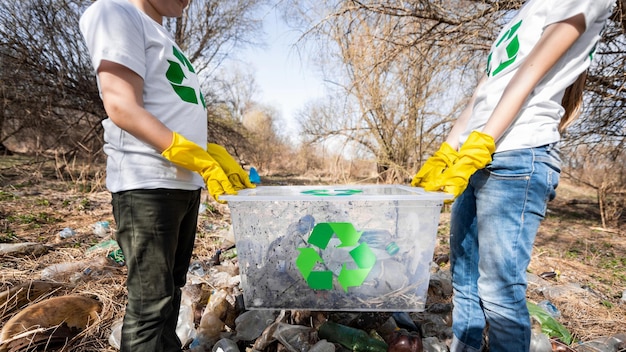 Foto gratuita ragazzo e ragazza alla raccolta dei rifiuti di plastica