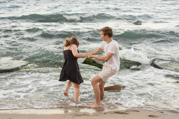 男の子と女の子が海で一緒に遊んで